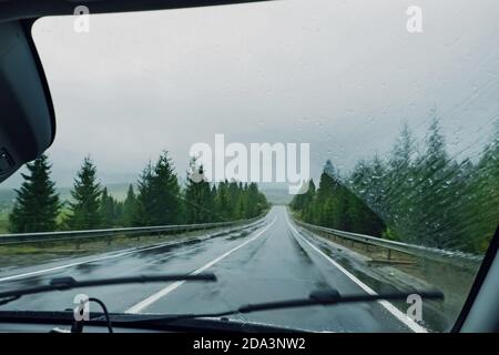 Guidando lungo l'autostrada di montagna in una giornata piovosa Foto Stock