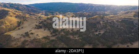 La luce del sole dorata splende sulle colline ondulate della California del Nord. Queste belle colline erose diventano verdi una volta che l'inverno porta pioggia stagionale. Foto Stock