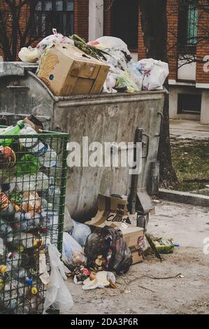 Spazzatura spazzatura essere troppo pieno di spazzatura in città, immagine verticale. Concetto di problema ambientale ed ecologico, inquinamento fondiario e rifiuti plastici. Foto Stock