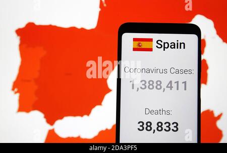 In questa illustrazione della foto, le statistiche del coronavirus di Covid-19 sparsi in Spagna sono visualizzate su uno smartphone con uno sfondo di una mappa che mostra il coronavirus di Covid-19 diffusione globale su uno schermo del computer.i casi globali di Covid-19 passano 50 milioni e 10 milioni negli Stati Uniti, secondo internet tracker online del coronavirus diffusione. Foto Stock