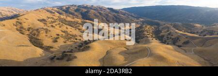 La luce del sole dorata splende sulle colline ondulate della California del Nord. Queste belle colline erose diventano verdi una volta che l'inverno porta pioggia stagionale. Foto Stock