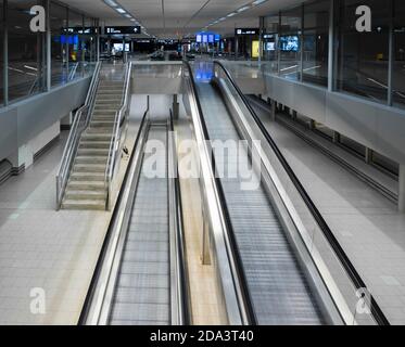 Zurigo, Svizzera - 13 ottobre 2020: Scale mobili vuote in un edificio desertato del terminal dell'aeroporto di Zurigo Kloten in occasione della pandemia mondiale del Covid. Foto Stock