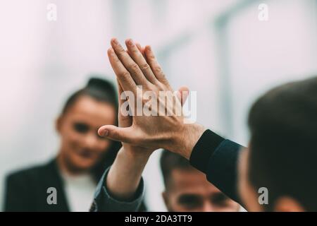 primo piano. giovani dipendenti che si danno a vicenda un alto cinque Foto Stock