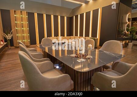 Sala da pranzo e zona salotto in appartamento di lusso mostra casa mostra arredamento arredamento arredamento arredamento interni candele sul tavolo Foto Stock