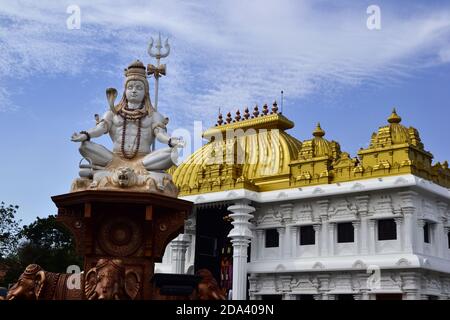Statua di Shiva vicino al tempio induista con tetto dorato luminoso. Sri Ramayana Darshanam & BharatMata Sadanam, Kanyakumari, India Foto Stock