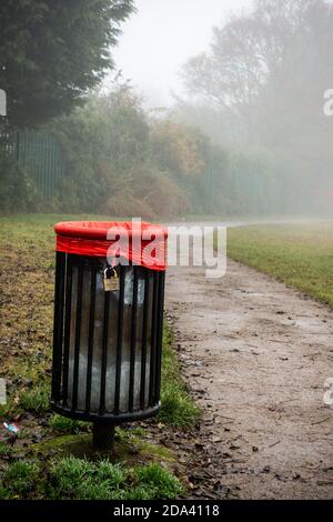 bidone dei rifiuti nel parco pubblico in nebbia Foto Stock