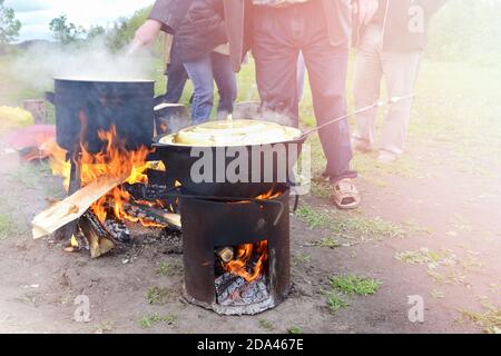 Cucinare in un calderone sopra un fuoco aperto. Concetto di attività ricreative all'aperto Foto Stock