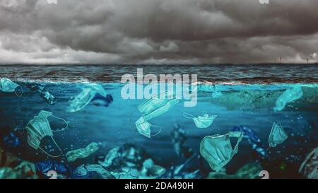 maschere chirurgiche e bottiglie di plastica in mare. rischio ambientale al momento della covid-19. Foto Stock