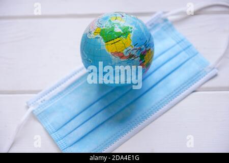 globo e maschera medica - pandemia globale - corona concetto di covid con messa a fuoco selettiva Foto Stock