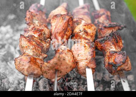Il barbecue viene grigliato sulla griglia. Carne o shish kebab sul fuoco Foto Stock