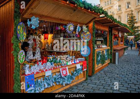 Chioschi in legno su strade acciottolate che vendono regali e souvenir durante il famoso mercato di Natale tradizionale a Vienna, Austria. Foto Stock