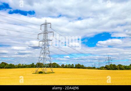 Linee elettriche e tralicci elettrici che attraversano un campo vicino a Baldock e Letchworth Garden City, Hertfordshire, Regno Unito Foto Stock