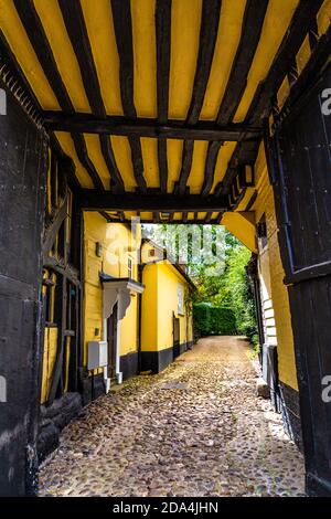 Passaggio attraverso una casa in stile Tudor giallo vicino alla Chiesa di Santa Maria la Vergine su Church Street, Baldock, Hertfordshire, Regno Unito Foto Stock