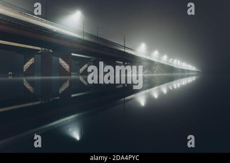 Ponte che si affievolisce in una nebbia notturna, ponte settentrionale, Voronezh, Russia Foto Stock