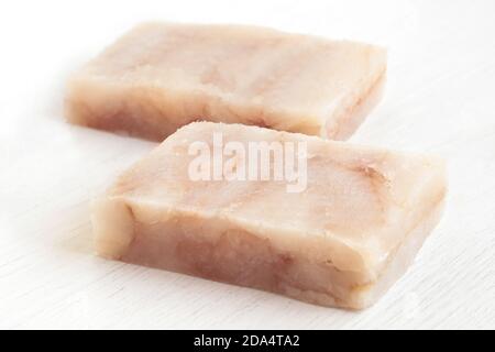 Due blocchi di filetti di pesce surgelati isolati su bianco. Foto Stock
