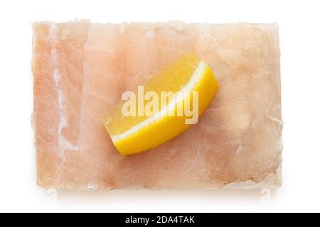 Filetto di pesce surgelato rapido con un cuneo di limone isolato su bianco. Vista dall'alto. Foto Stock