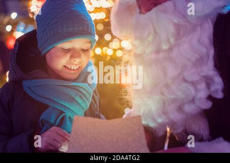 Bambino che apre un regalo che ha ricevuto da Babbo Natale Foto Stock