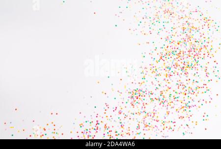 Un sacco di brillanti confetti natalizi su uno sfondo bianco isolato vista dall'alto Foto Stock