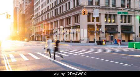 Persone che camminano attraverso l'incrocio di via vuota sulla Fifth Avenue Il passato salì sugli edifici durante il blocco del coronavirus a New Città di York 2020 Foto Stock