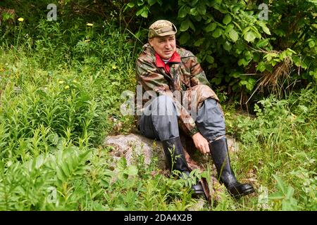 uomo viaggiatore vestito in stile militare, cambiando stivali utilizzando un footwrap invece di una calza Foto Stock