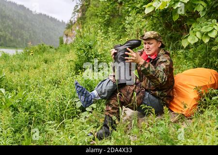 uomo viaggiatore vestito in stile militare, cambiando stivali utilizzando un footwrap invece di una calza Foto Stock