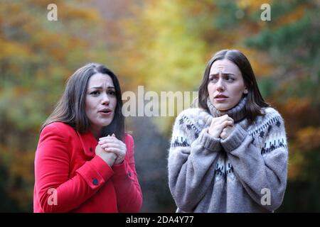 Due donne si lamentano di aver camminato a freddo in un parco autunno Foto Stock