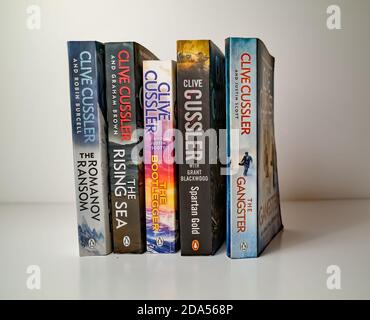 Norwich, Norfolk, Regno Unito – Novembre 08 2020. Foto editoriale illustrativa di una selezione di libri cartacei di genere thriller scritti da Clive Cussler isolat Foto Stock