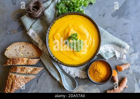 Deliziosa zuppa di carote cremosa con polvere di curcuma e baguette per colazione Foto Stock