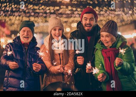 Ritratto di bella bella allegra allegria allegra famiglia divertendosi visita il mercato urbano di strada conto alla rovescia celebrazione di mezzanotte bruciando festale bengala fuoco Foto Stock