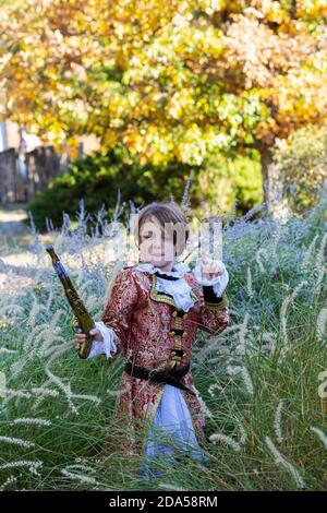 Ragazzo vestito da pirata che tiene lunga pistola. Foto Stock