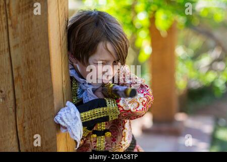 Ragazzo vestito da pirata che tiene lunga pistola. Foto Stock