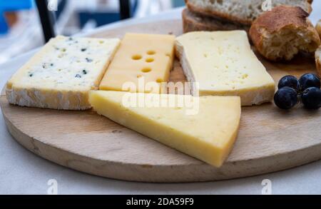 Collezione di formaggi francesi su tavola di marmo, emmental, carre de aurillac, petit cantal AOP Jeune, buche chevre e brie Foto Stock