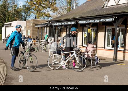 I ciclisti spingono o sfreccia biciclette all'esterno del Lakeside Café Alexandra Palace Park con la gente ai tavoli mangiare London Borough of Autunno Haringey Foto Stock