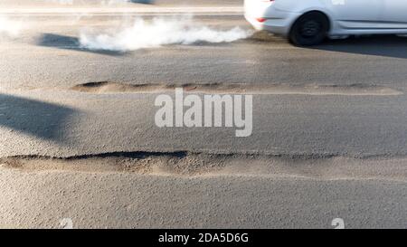 Rut su strada asfaltata in città. Strada che richiede riparazione, esempio di corruzione nella riparazione di strade in Russia Foto Stock