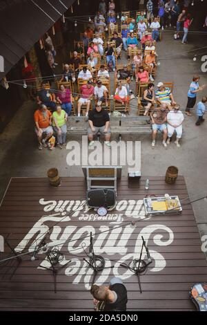 Vista dall'alto del musicista solista sul palco della distilleria Ole Smoky Moonshine, con un pubblico di appassionati di musica bluegrass a Gatlinburg, TN, Foto Stock