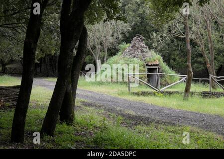 Antico rifugio di pastori o bruciatori a carbone a forma di cono nel Parco dell'Etna, in Sicilia Foto Stock