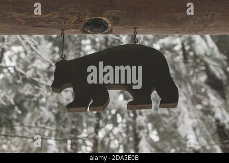 Legno orso segno Hanging esterno con una neve, scena invernale in background Foto Stock