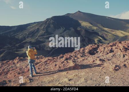 Indietro vista turistica femminile scattare foto della cima Etna Vulcano con telefono cellulare, Sicilia Foto Stock