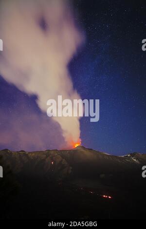 Fumo dal vulcano Etna durante un'eruzione notturna contro il cielo stellato, Sicilia Foto Stock