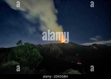 Fumo dal vulcano Etna durante un'eruzione notturna contro il cielo stellato, Sicilia Foto Stock