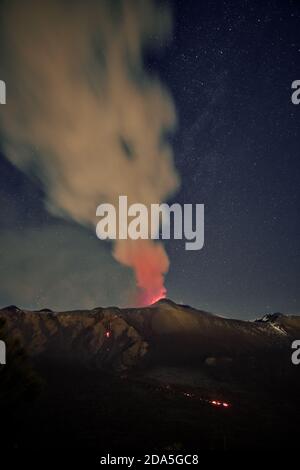 Fumo dal vulcano Etna durante un'eruzione notturna contro il cielo stellato, Sicilia Foto Stock