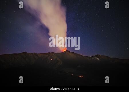 Fumo dal vulcano Etna durante un'eruzione notturna contro il cielo stellato, Sicilia Foto Stock