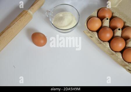 Uovo, cannella, miele, farina di mandorle, semi di lino, estratto di vaniglia, sale. Ingredienti per muffin al pane, spilla, stella di anis sullo sfondo bianco Foto Stock