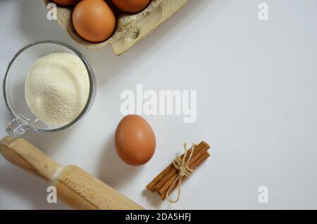 Uovo, cannella, miele, farina di mandorle, semi di lino, estratto di vaniglia, sale. Ingredienti per muffin al pane, spilla, stella di anis sullo sfondo bianco Foto Stock