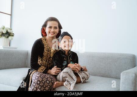 Ritratto di una madre felice con suo figlio. Il concetto giavanese è isolato nel soggiorno Foto Stock