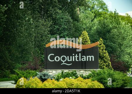 Una vista del segno 'Benvenuti a Coquitlam' con la foresta verde sullo sfondo Foto Stock