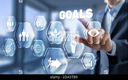 Concetto di raggiungimento degli obiettivi. Uomo preme il dito su uno schermo virtuale. Foto Stock