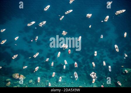 Vista dalla cima di molte piccole barche in mare, in una bella giornata estiva soleggiata. Isola di Capri. Foto Stock