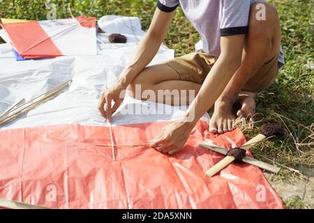 il giovane si sta preparando a una carta sagomata da apporre il aquilone Foto Stock