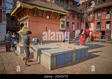 Patan, Nepal, gennaio 2016. Due bambini che giocano a ping-pong sulla strada. Foto Stock